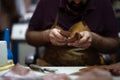 Leather craftsman at work shaping pieces into wallets in a busy workshop Royalty Free Stock Photo
