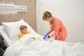 Focused little boy on the bed is looking to the medical worker is the hospital Royalty Free Stock Photo