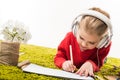 focused little child drawing with color pencils and listening music on green soft carpet Royalty Free Stock Photo