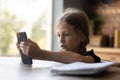 Focused little girl using smartphone for video call Royalty Free Stock Photo