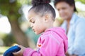 Focused on the little things - Learning. A side view of a pre-school ethnic girl looking down at a bug with interest. Royalty Free Stock Photo