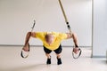 A focused male athlete performing an exercise on functional loops in the gym Royalty Free Stock Photo