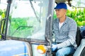 Focused male farmer sits at the wheel of an agricultural forklifttruck Royalty Free Stock Photo