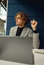 Focused male freelancer making notes during working on laptop sitiing desk in coworking Royalty Free Stock Photo