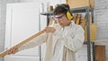 A focused man inspecting wood quality in a well-organized carpentry workshop Royalty Free Stock Photo