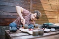 Focused man screwing skateboard truck to deck