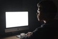 Focused man using blank screen computer in dark room Royalty Free Stock Photo