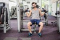 Focused man using weights machine for arms