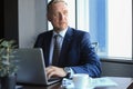 Focused mature businessman deep in thought while sitting at a table in modern office