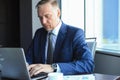 Focused mature businessman deep in thought while sitting at a table in modern office