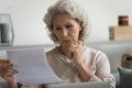 Focused mature 60s retired lady receiving letter
