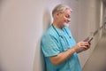 Clinician using his mobile phone in inpatient facility corridor