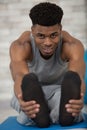 focused mid adult man stretching leg while practicing yoga Royalty Free Stock Photo