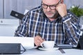 Focused middle age man writing at his home office