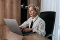 Focused middle-aged businesswoman sitting at desk typing working on laptop, browse wireless internet. Concentrated Royalty Free Stock Photo