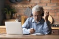 Focused middle aged man in headphones studying on online courses.