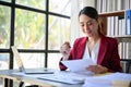 Focused millennial Asian businesswoman examining financial report, working at her desk in office Royalty Free Stock Photo