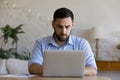 Focused millennial business man using laptop at table Royalty Free Stock Photo