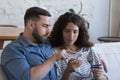 Focused millennial husband teaching wife to use online payment app