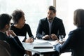 Focused mixed race employees listening to team leader. Royalty Free Stock Photo