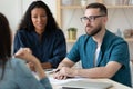 Focused mixed race hr managers listening to young job applicant. Royalty Free Stock Photo