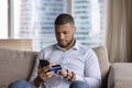 Focused mobile phone user man using credit card Royalty Free Stock Photo