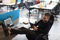 Focused modern businessman working and taking notes in his modern office, legs on desk Royalty Free Stock Photo