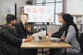 Focused multiracial business people in conference room, looking at a laptop, having video conference Royalty Free Stock Photo