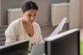 focused multiracial businesswoman holding document while