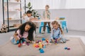 focused multiracial preschoolers playing with wooden blocks