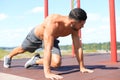 Focused muscular guy doing plank exercise outdoors Royalty Free Stock Photo