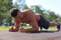 Focused muscular guy doing plank exercise outdoors Royalty Free Stock Photo