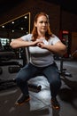 Focused overweight girl squatting with clenched hands