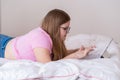 Focused overweight teen girl using touchpad of wireless keyboard to study on tablet