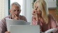 Focused pensive elderly retired married couple holding paper documents checking analyzing calculating bills bank loan Royalty Free Stock Photo