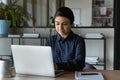 Focused positive Indian student girl using laptop for distance studying