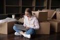 Focused positive renter woman typing on laptop on moving