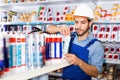 Focused workman choosing materials for renovation works in paint store