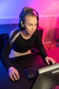 Focused Professional E-sport Gamer Girl with Headset Playing Online Video Game on PC Royalty Free Stock Photo