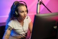 Focused professional e-sport gamer girl streaming and plays online video game on PC Royalty Free Stock Photo