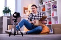 Focused professional video blogger carrying opened cardboard box