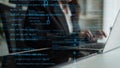 Focused programmer working on a laptop with digital code overlay, representing software development and technology Royalty Free Stock Photo