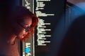 Focused programmer and software developer works in dark workspace, screen glowing with code. Scene highlights programming, coding Royalty Free Stock Photo
