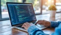 Programmer Working on Laptop with Code Editor in Bright Home Office Setting Royalty Free Stock Photo