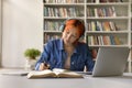 Focused red haired 17s student girl doing schoolwork Royalty Free Stock Photo