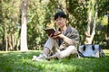 Focused and relaxed young Asian male college student chilling in the park, reading a book or novel Royalty Free Stock Photo