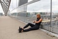 Focused Runner Sitting On Bridge After Running and Check Workout Performance Royalty Free Stock Photo