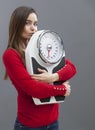 Focused 20s girl in love with her weighting scale for wellness and weight control