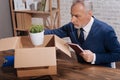 Focused sad executive putting his plant in a box