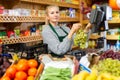 Focused saleswoman weighing grape on scale in grocery store Royalty Free Stock Photo